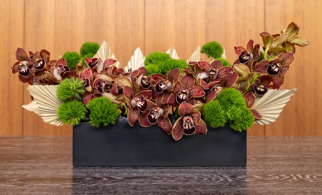 maroon-wide-flowers-on-wood-desk-in-lobby